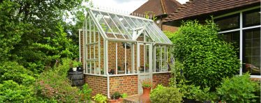 Front View of a White Hartley Botanic Bespoke Lean To Glasshouse With Brick Base.