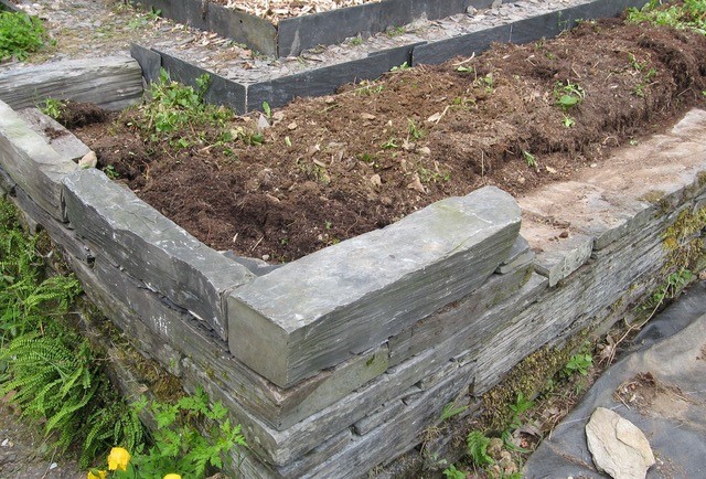 I used reclaimed slate and roofing tiles to retrofit my soil-spilling terrace beds. 
